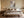Quiet Layers II abstract wall art in a light frame above a bed with neutral bedding.