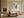 Framed textured abstract artwork above a cream sofa and low wooden coffee table.