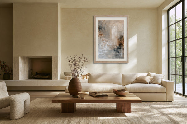 Framed textured abstract artwork above a cream sofa and low wooden coffee table.