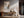 Light-framed abstract wall art above a wooden console with ceramic vases and branches.