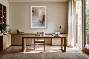 Quiet Layers II abstract print in a light frame above a wooden desk and chair.