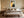 Copper Veil abstract wall art in a pale frame centered above a bed with neutral bedding.