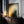 Large Copper Veil canvas with a thin dark edge leaning on a dark wooden cabinet beside candles.