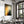 Large dark-framed Copper Veil artwork above a set dining table near tall windows.