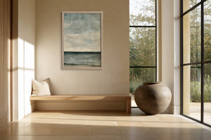 Framed blue-grey abstract artwork above a built-in bench beside floor-to-ceiling windows.