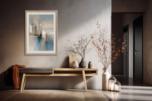 Framed blue and beige abstract artwork above a wooden bench with vases and branches.