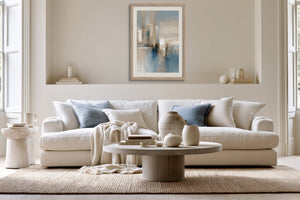 Blue Foundations I in a light wood frame above a cream sofa with blue cushions.