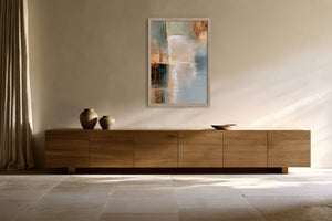 Copper Shore in a light wood frame above a low wooden sideboard.