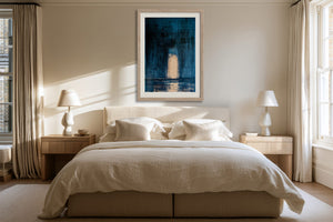 Framed blue abstract artwork with a glowing arch hangs above a bed between two windows.