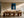 Framed blue abstract artwork with a pale arch above a long wooden dining table.