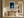 Framed blue abstract artwork with a pale arch hangs above a rustic wooden bench.