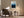 Light wood-framed mountain artwork above an armchair, side table, and black floor lamp.