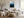 Light wood-framed mountain artwork above a white sofa and wooden coffee table.