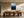 Light wood-framed mountain artwork above a long wooden dining table with sculptural chairs.