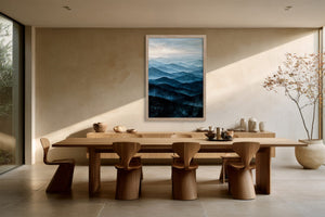 Light wood-framed mountain artwork above a long wooden dining table with sculptural chairs.