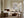 Framed pale abstract artwork above a fireplace in a living room with curved seating.