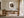 Framed bird nest artwork with three speckled eggs above a wooden desk in a home office.