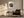 Framed bird nest artwork with three speckled eggs beside an armchair, floor lamp, and small table.