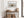 Dune grass artwork in a pale wood frame above a rustic console with woven baskets.