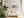 Dune grass artwork in a pale wood frame above a cream sofa with white cushions and curtains.