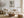 Light wood-framed windmill artwork above a white sofa with a rustic round coffee table.