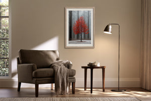Light wood-framed red-leaved tree artwork above an armchair, side table, and black floor lamp.