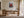 Light wood-framed red-leaved tree artwork displayed above a wooden desk with chair and lamp.