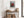 Light wood-framed red-leaved tree artwork above a rustic console table with woven baskets.