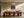 Light wood-framed red-leaved tree artwork centered above a long wooden dining table and chairs.