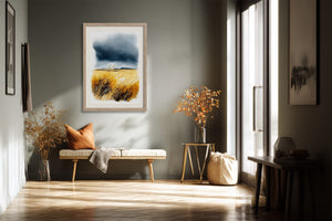 Light wood-framed dune grass watercolour above a bench with an orange cushion in a sunlit space.