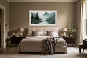 Framed misty mountain river watercolor hanging above a bed between two dark wood nightstands.