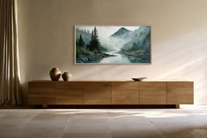 Framed mountain river watercolor displayed above a long wood sideboard with ceramic vessels.