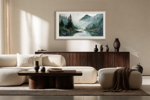 Framed misty river and mountain watercolor above a dark wood credenza in a seating area.