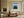 Light wood-framed rowboat artwork above a cream sofa and low wooden coffee table.