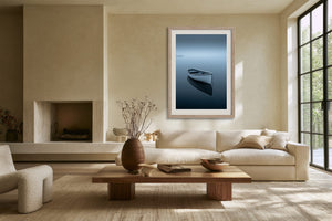 Light wood-framed rowboat artwork above a cream sofa and low wooden coffee table.
