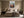 Light wood-framed mountain valley artwork centered above a bed with matching bedside tables.