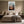 Light wood-framed mountain valley artwork centered above a bed with matching bedside tables.