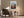 Light wood-framed mountain valley artwork above an armchair, side table, and floor lamp.