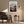 Light wood-framed mountain valley artwork above an armchair, side table, and floor lamp.