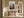Light wood-framed mountain valley artwork above a rustic console table in a sunlit hallway.