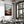 Large black-framed mountain valley artwork above a dining table set with dishes and candles.