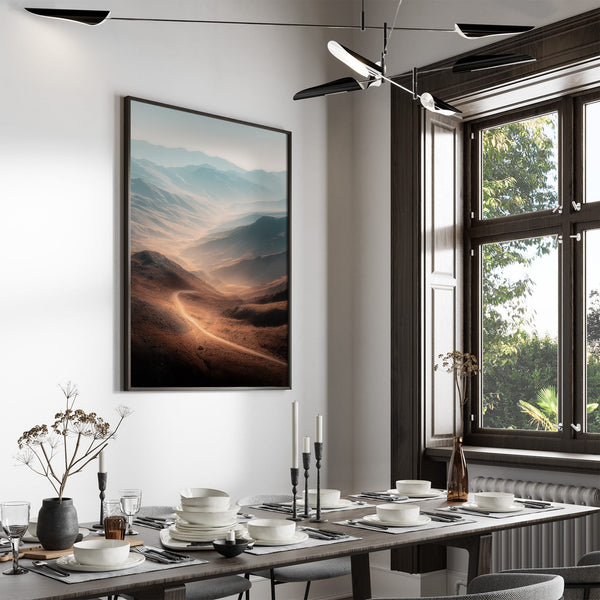 Large black-framed mountain valley artwork above a dining table set with dishes and candles.
